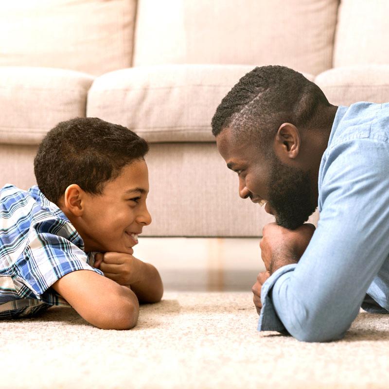 Man and child smiling face to face