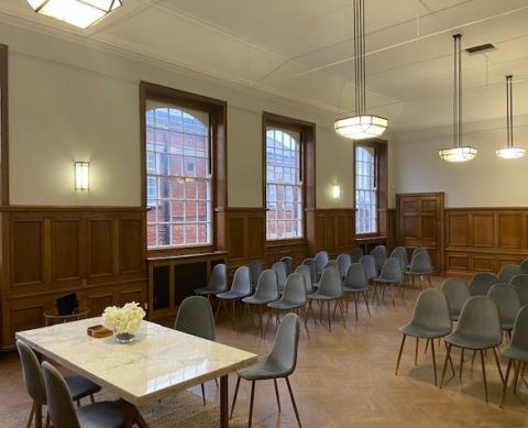 Room with table and chairs at front and group of chairs behind