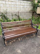 Lionhead bench with plaque on paved slabs